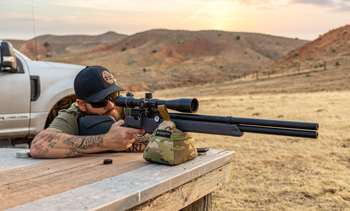 Shooter at a shooting bench with Umarex Origin